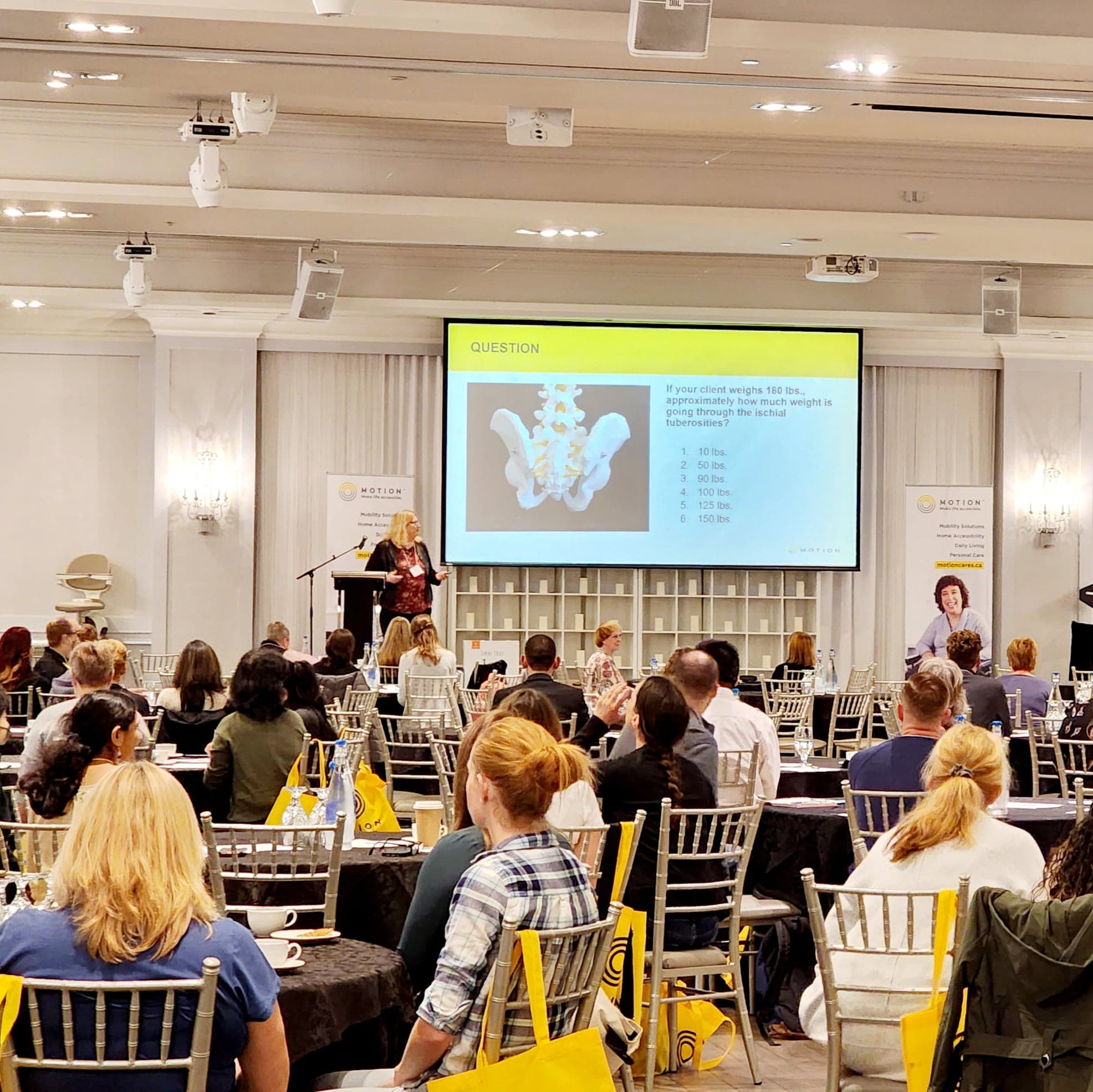 Motion Rehab Expo - View of attendees seated at tables and listening to keynote presentation