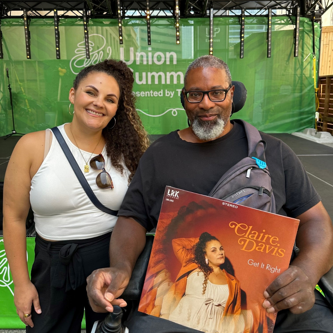Garrick next to Claire Davis. He is holding her album.